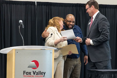 staff members smiling and laughing on stage at FVTC