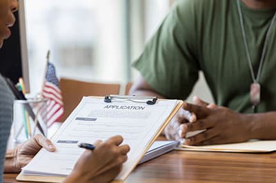 military veteran shaking hands with woman across table