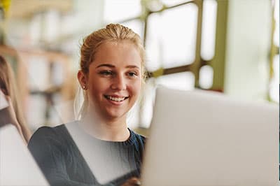 student working on laptop in library