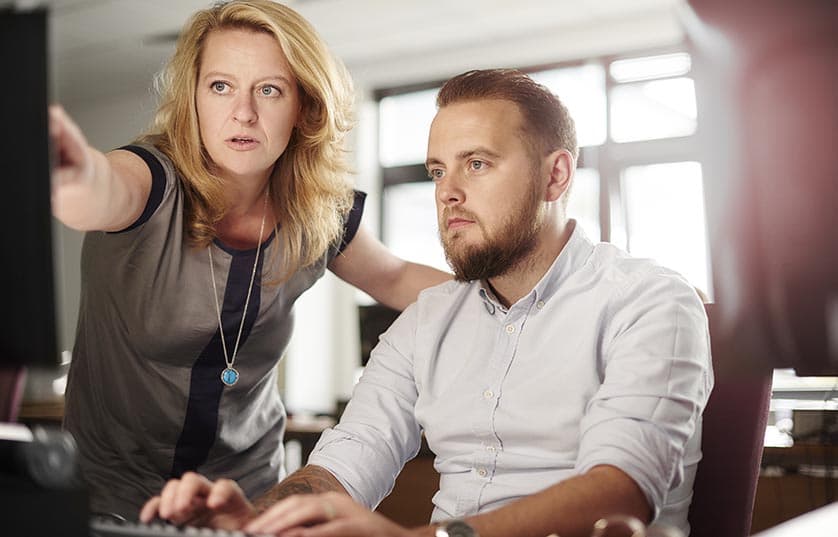 teacher helping student at a computer