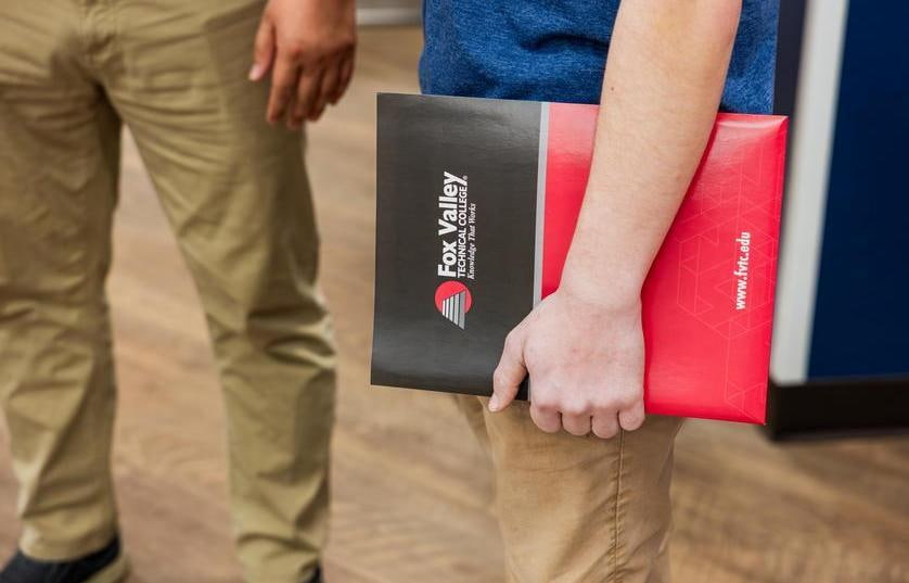 a person holding a Fox Valley Tech folder