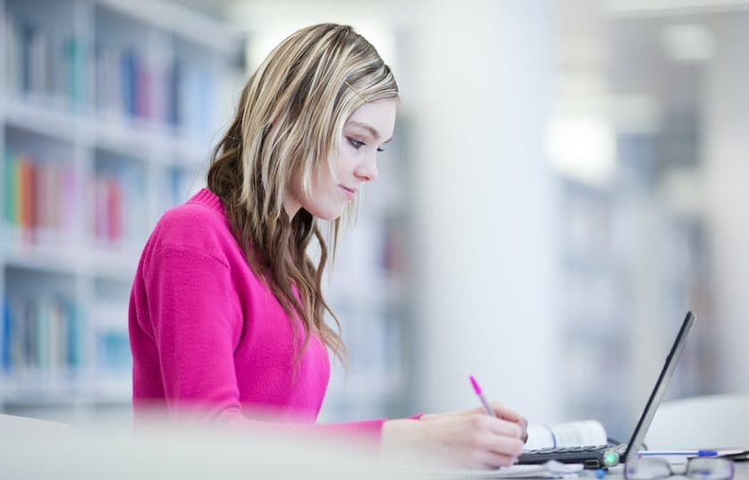 student working on laptop in library