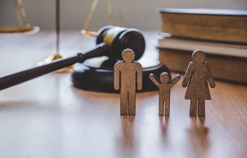 small wooden people standing on desk near gavel