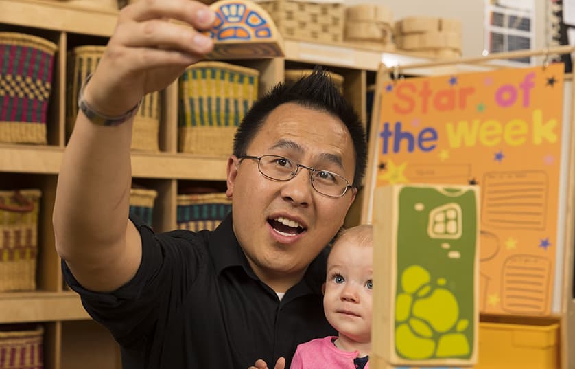 childcare teacher with toddler playing with blocks