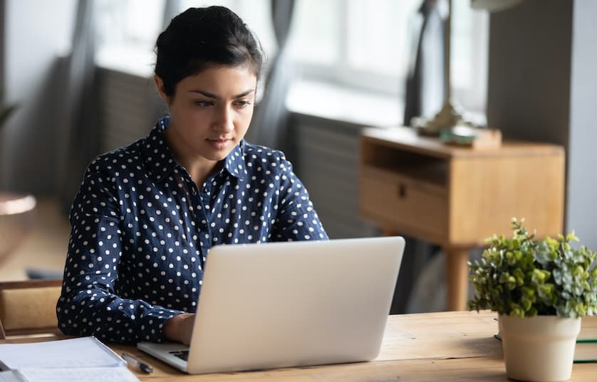 Woman at table working on laptop