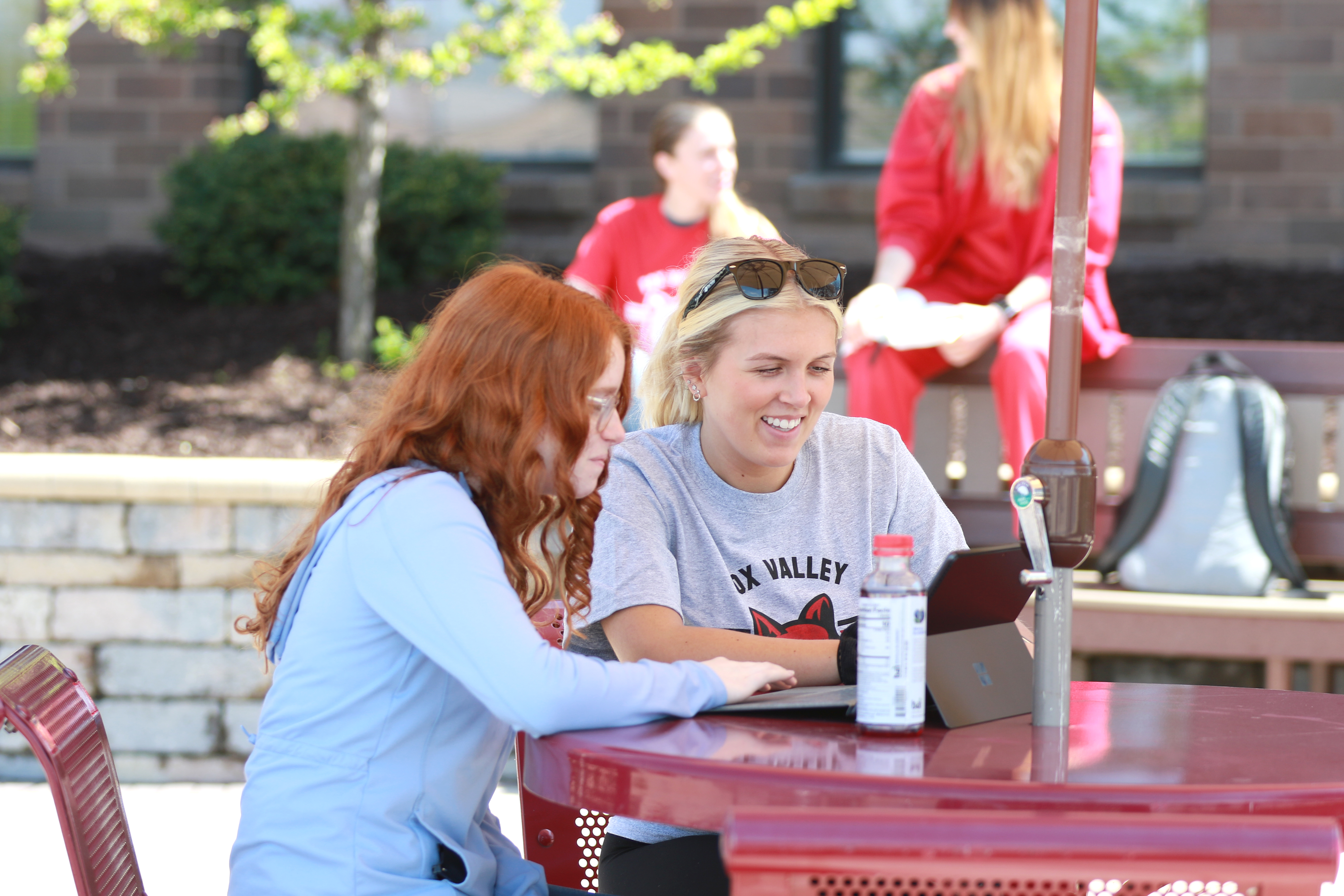 Fox Valley Tech students working on laptop at table outside