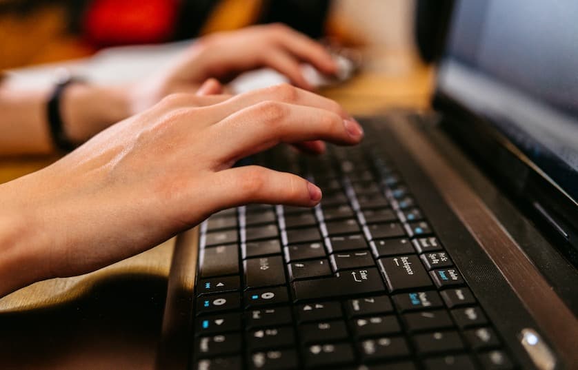 Typing on a laptop at a table