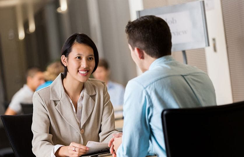 two people in office setting talking