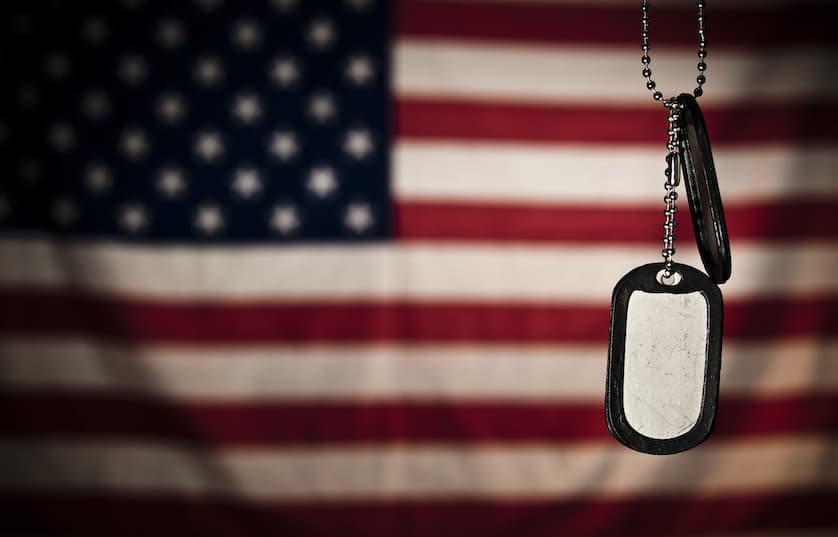Member of the United States military standing with an American flag