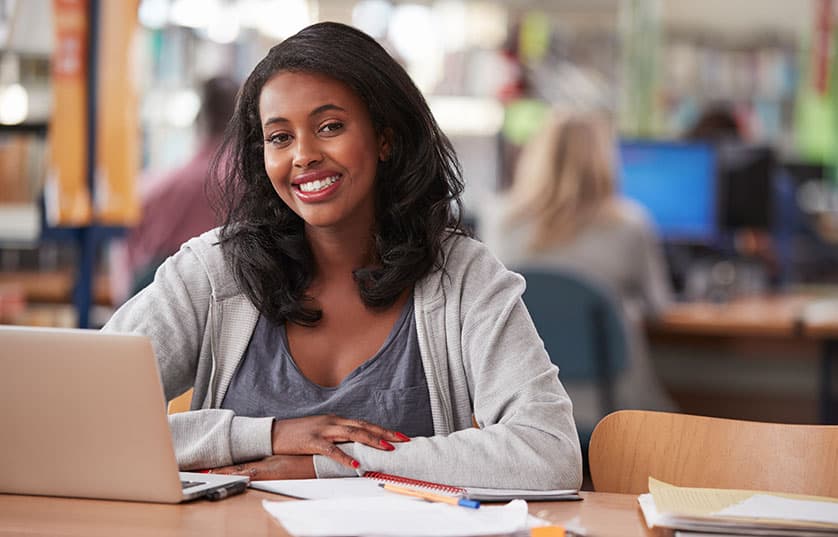 Student with laptop in library