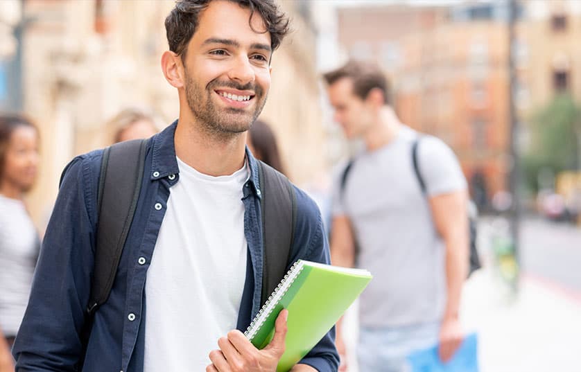 Student with notebook in city