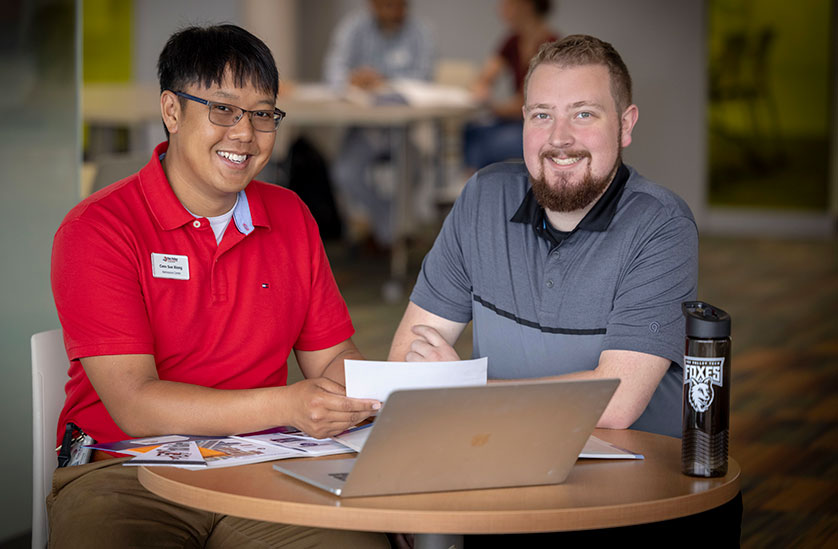 student with laptop and book