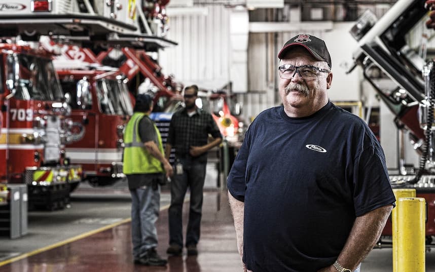 people standing in warehouse with firetrucks