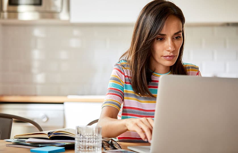 woman sitting at a table working on laptop