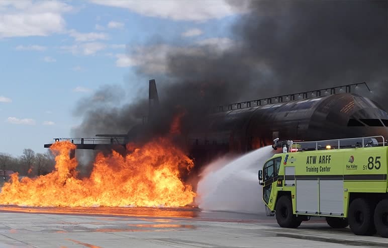 FVTC ARFF Training Center airplane on fire with striker vehicle spraying water