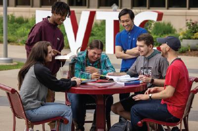 students sitting on FVTC campus in the yard