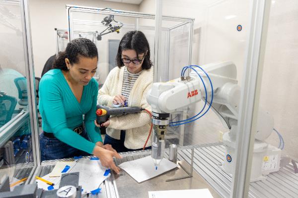 two students working in a automated manufacturing lab