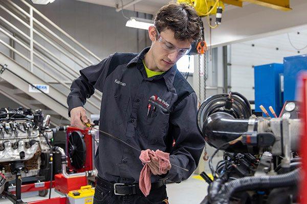 FVTC student checking vehicle oil in automotive shop
