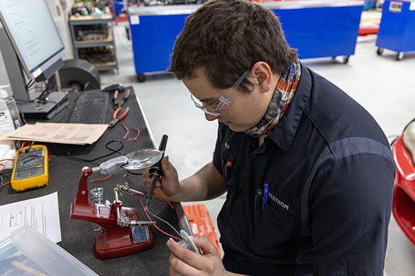 automotive technician working on part for car