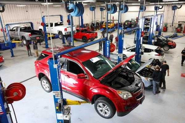 service technicians working on a vehicles in automotive lab