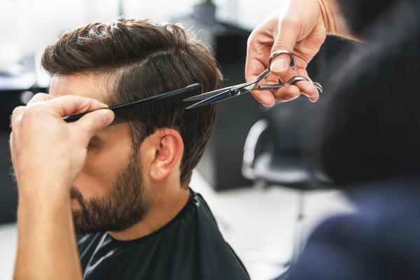 man in barbershop getting hair trimmed