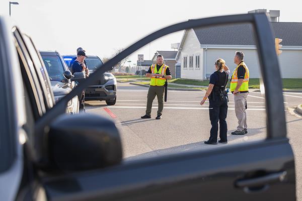 police officer trainee handcuffing person on ground with training police car and FVTC Public Safety Training Center grounds in background