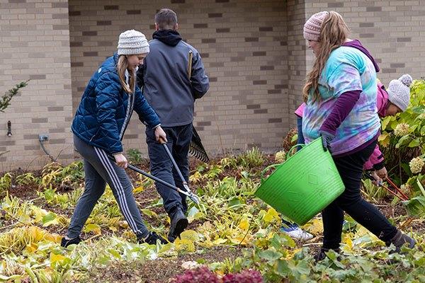 people with garden tools and buckets doing landscape work