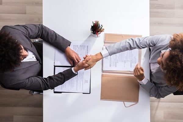 two people shaking hands across a table