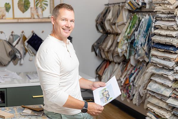 student in interior design classroom flipping through fabric swatch book