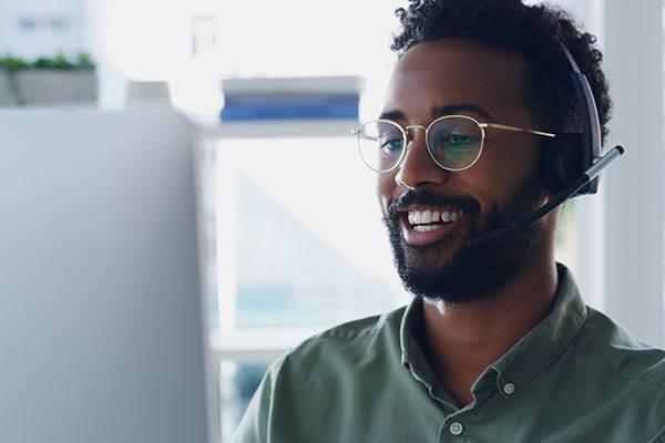 smiling man with headset working at computer