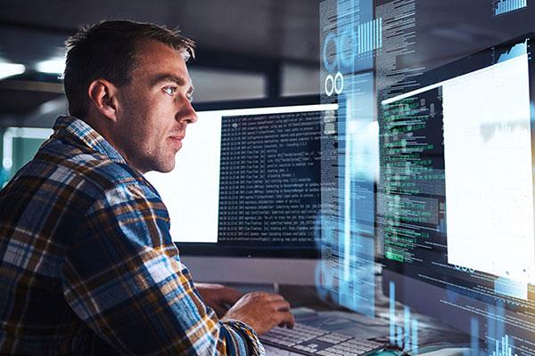 software developer in front of several monitors