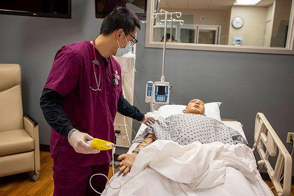 nursing student in lab monitoring patient