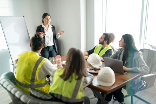 staff around a table discussing manufacturing safety