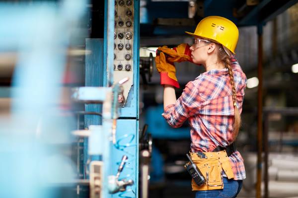 manufacturing technician working on equipment in factory