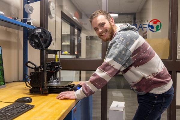 mechanical design student working on a project in lab