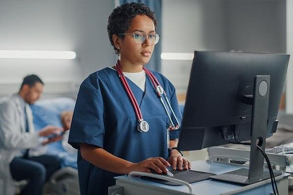 nurse recording patient data on a computer