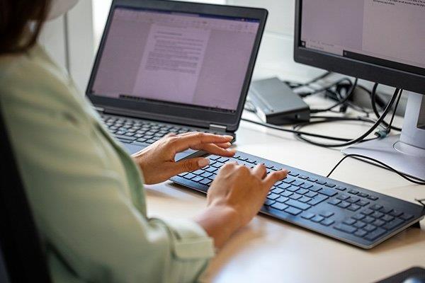 office assistant working at desk in front of a computer