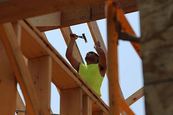 construction worker on building swinging a hammer