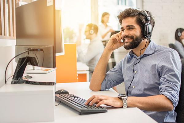 sales specialist with headset on computer