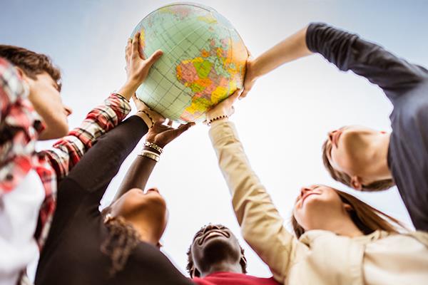 group of students holding a world globe