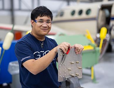 smiling man working on aircraft equipment