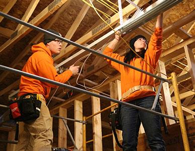 two students working on an electrical building project