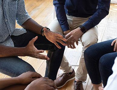 looking down at group of four people sitting in circle together