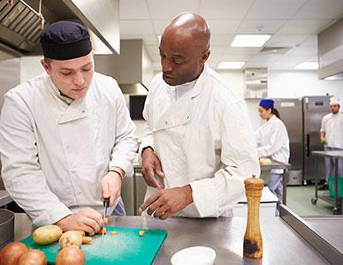 instructor and student working on a culinary project