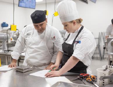 instructor and student working on a culinary project