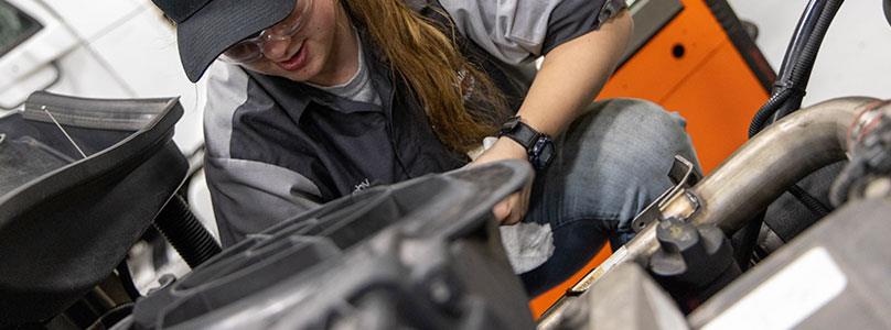 student working on a diesel engine