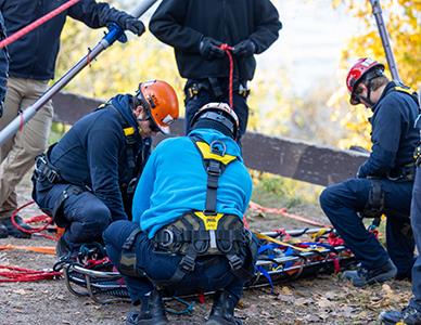 firefighting students performing a mock rope rescue at High Cliff State Park
