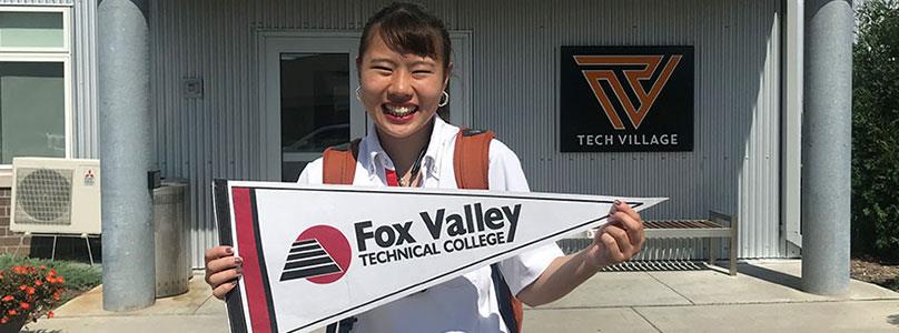 fox valley tech student holding up a pennant