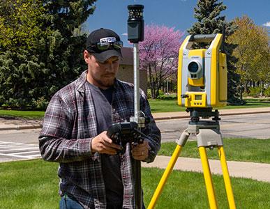 man using a surveying machine outside