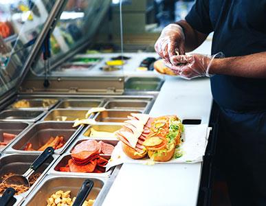 person making a submarine sandwich